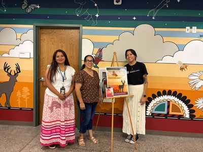 Three women in front of mural